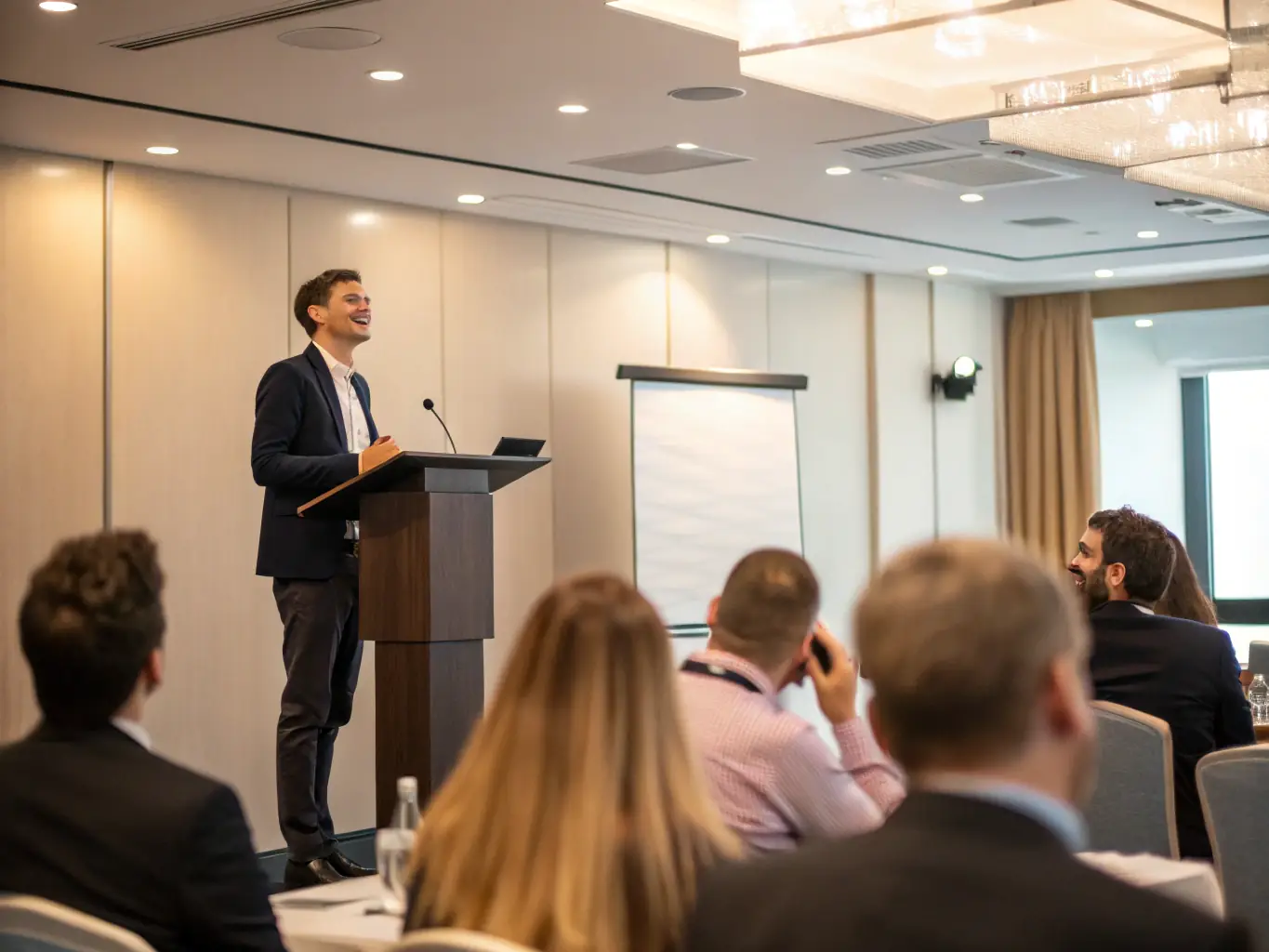 A keynote speaker delivering an engaging presentation on stage at the Corporate Culture Conference, with a large screen displaying key data points and insights.